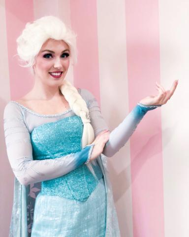 Elsa is smiling and ready to make a flurry with her iconic ice hand pose
