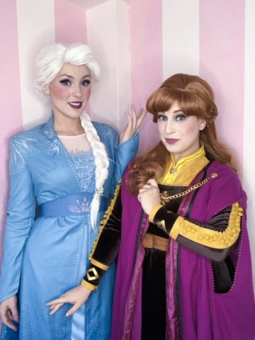Anna and Elsa are posing in their new Frozen 2 costumes